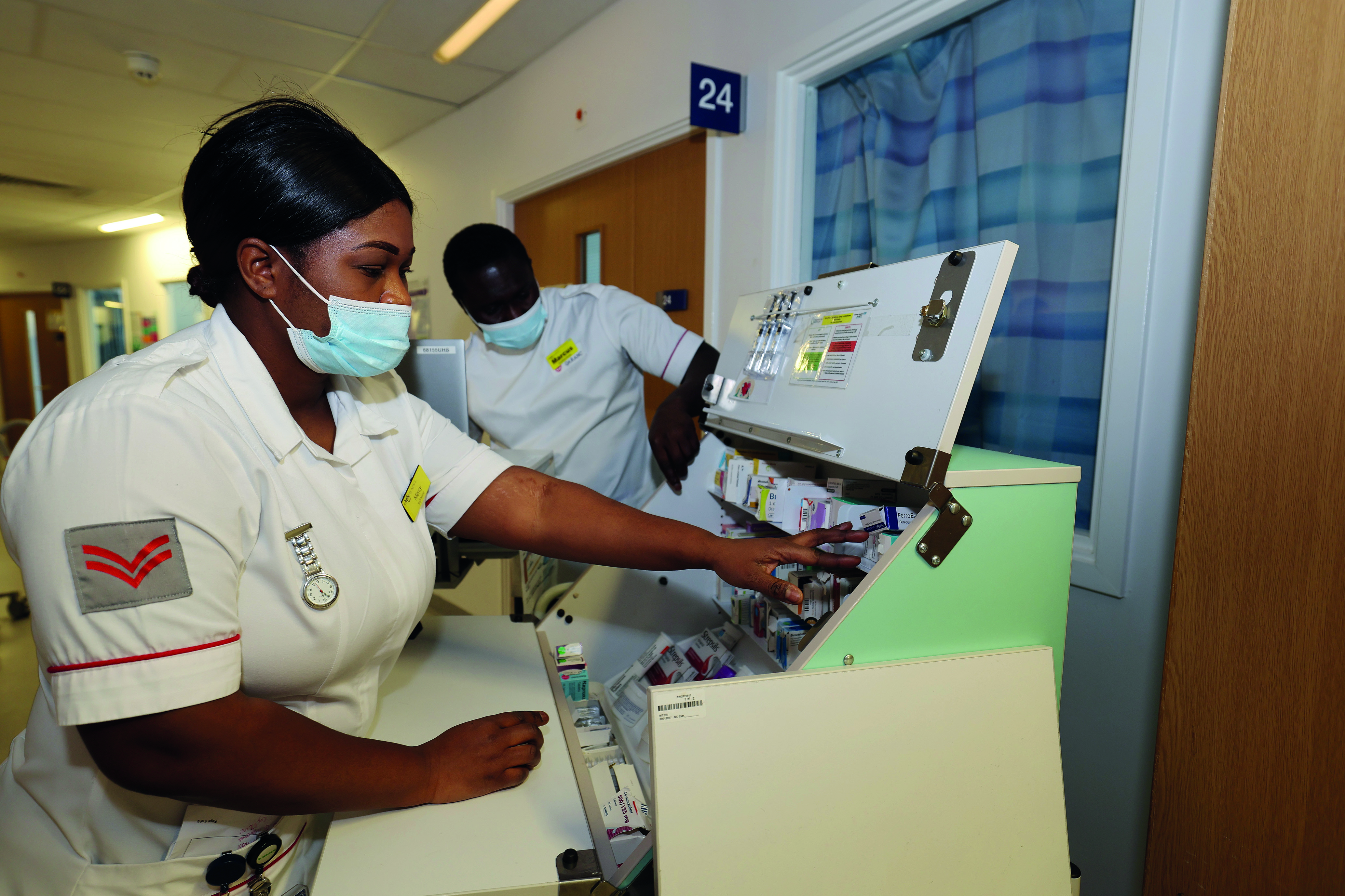 2 doctors looking through medication cabinet 