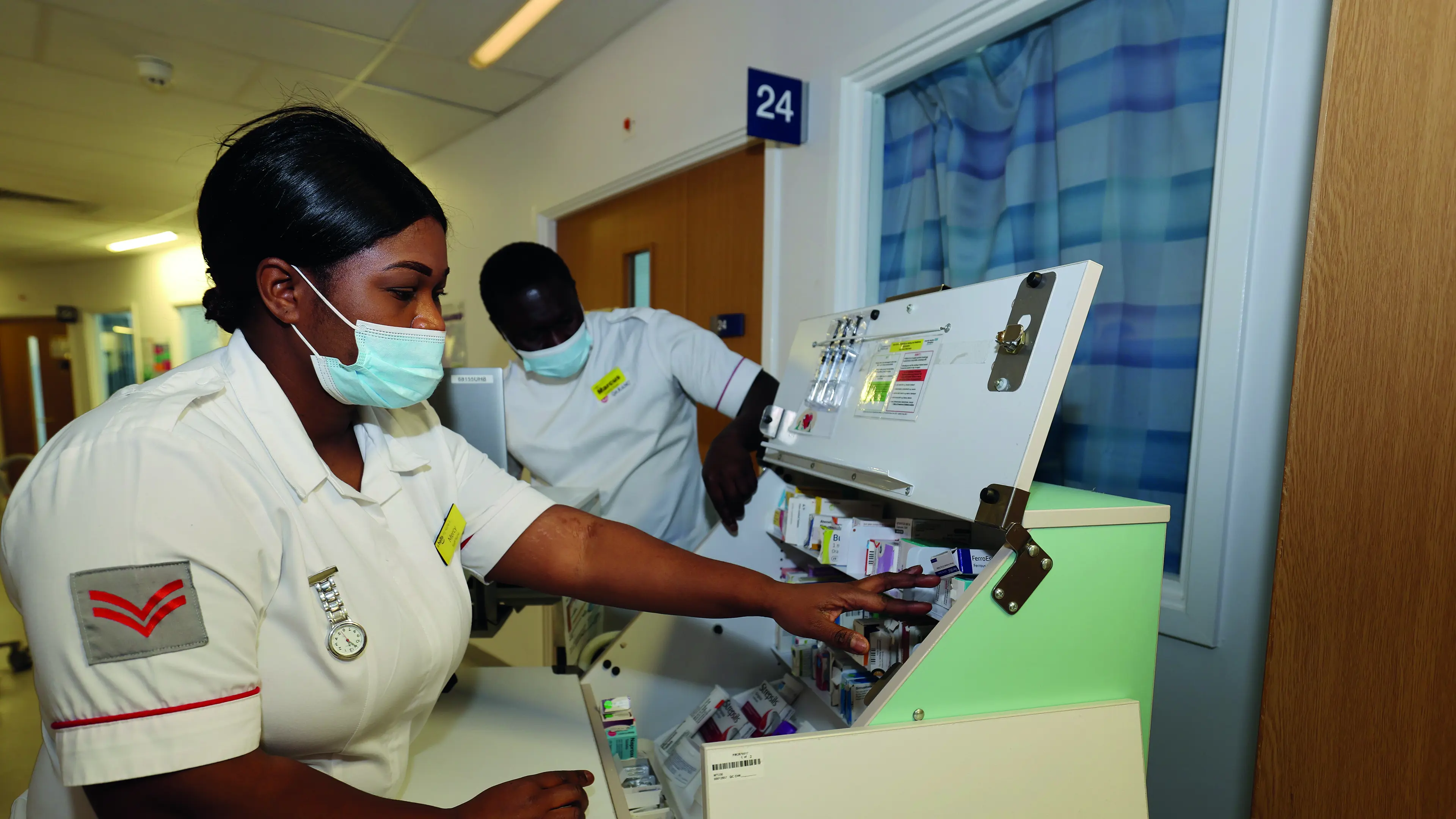 2 doctors looking through medication cabinet