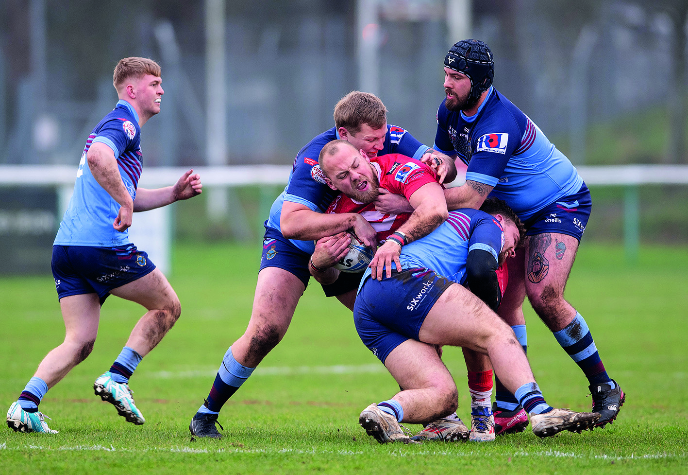 Group of men playing rugby in a tackle
