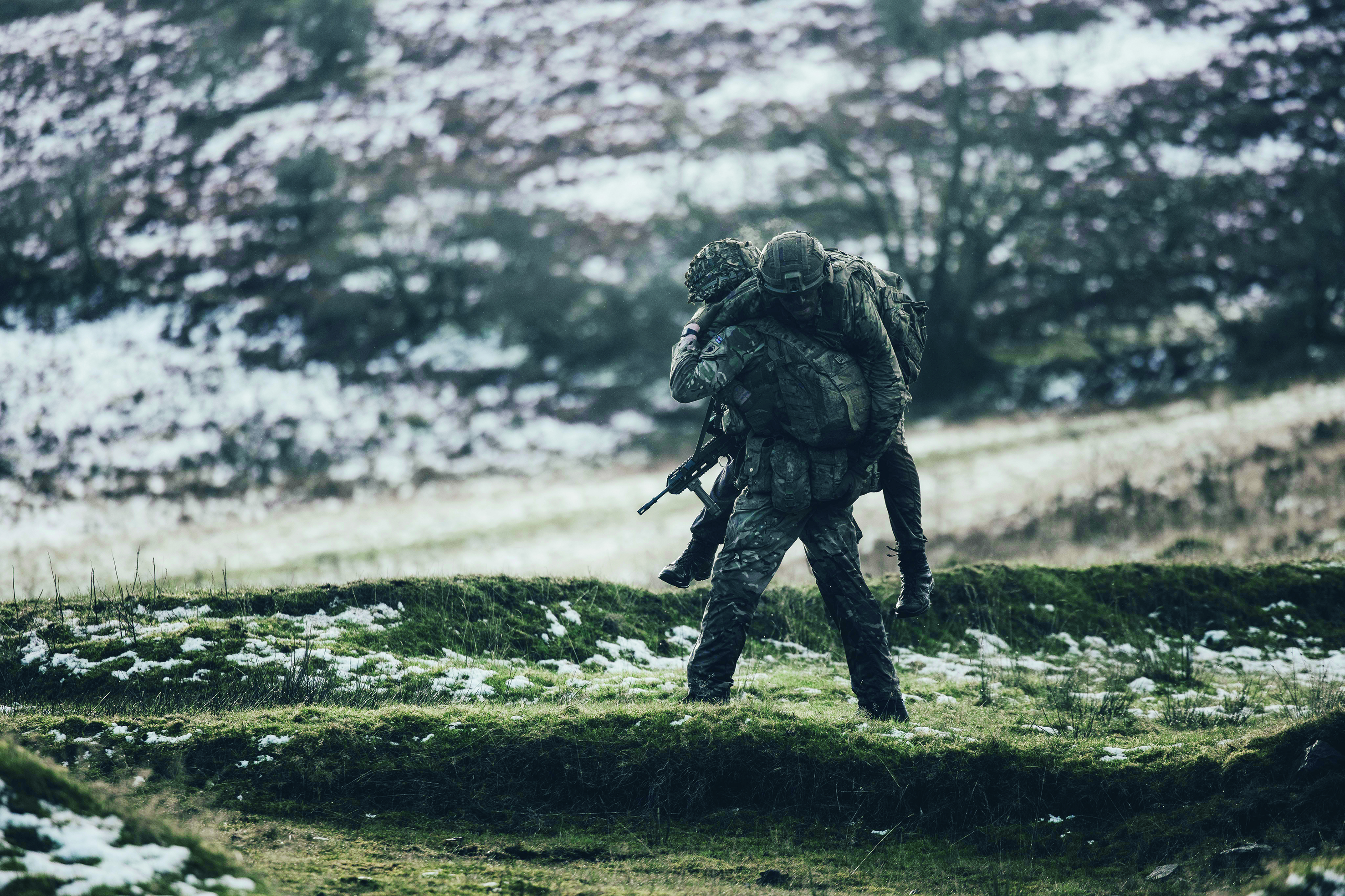 A soldier carrying another soldier on his back