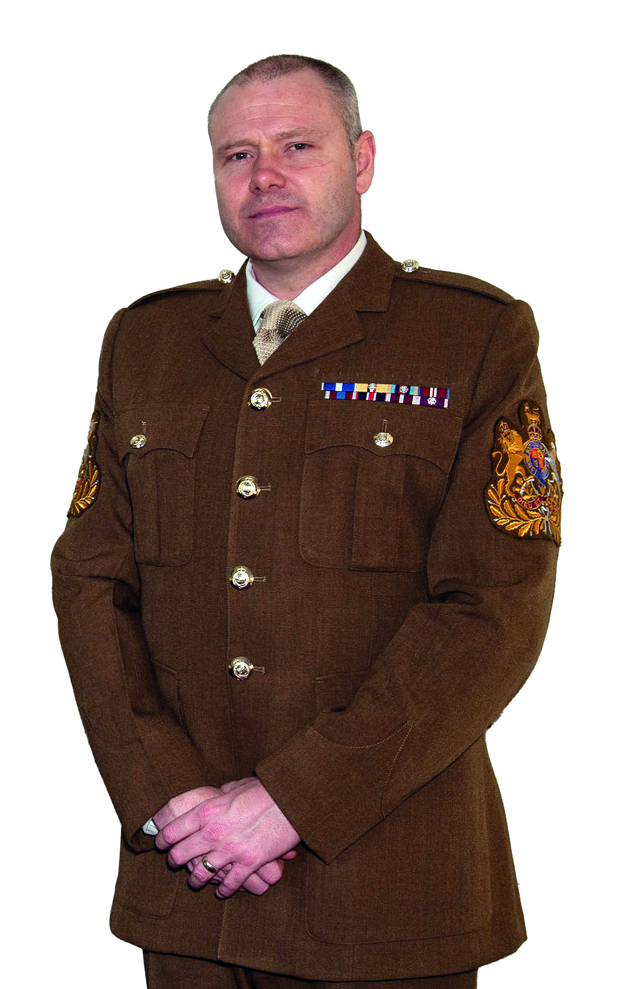 Male soldier with hands folded wearing brown uniform suit