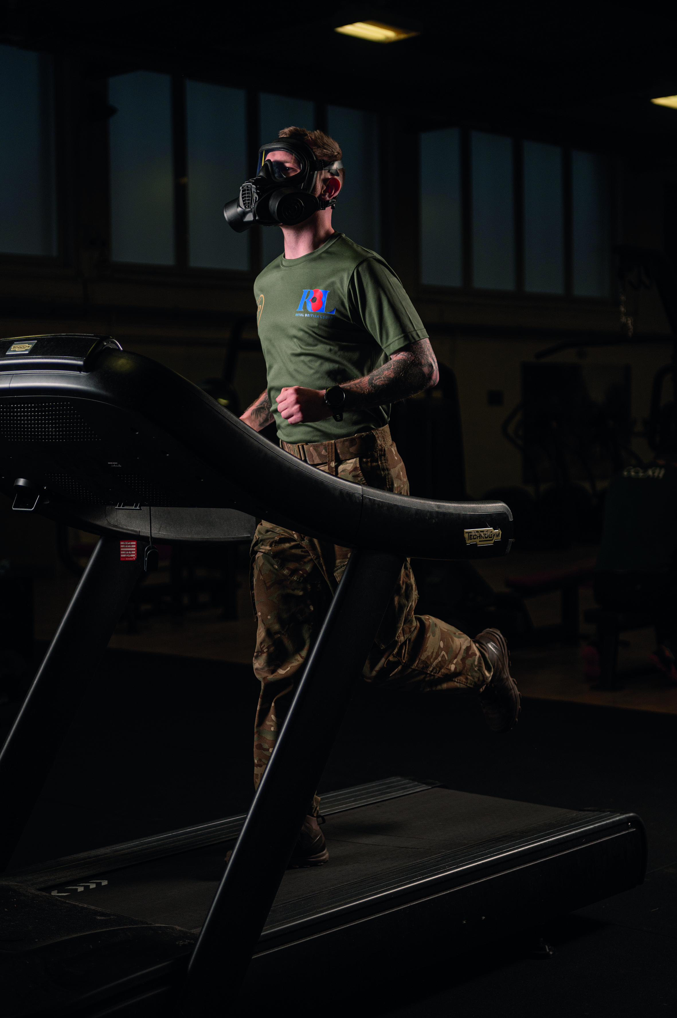 Soldier running on treadmill while wearing gas mask