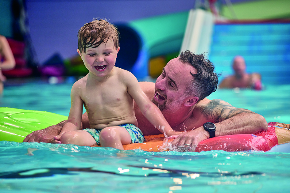 Man and child laughing in a pool