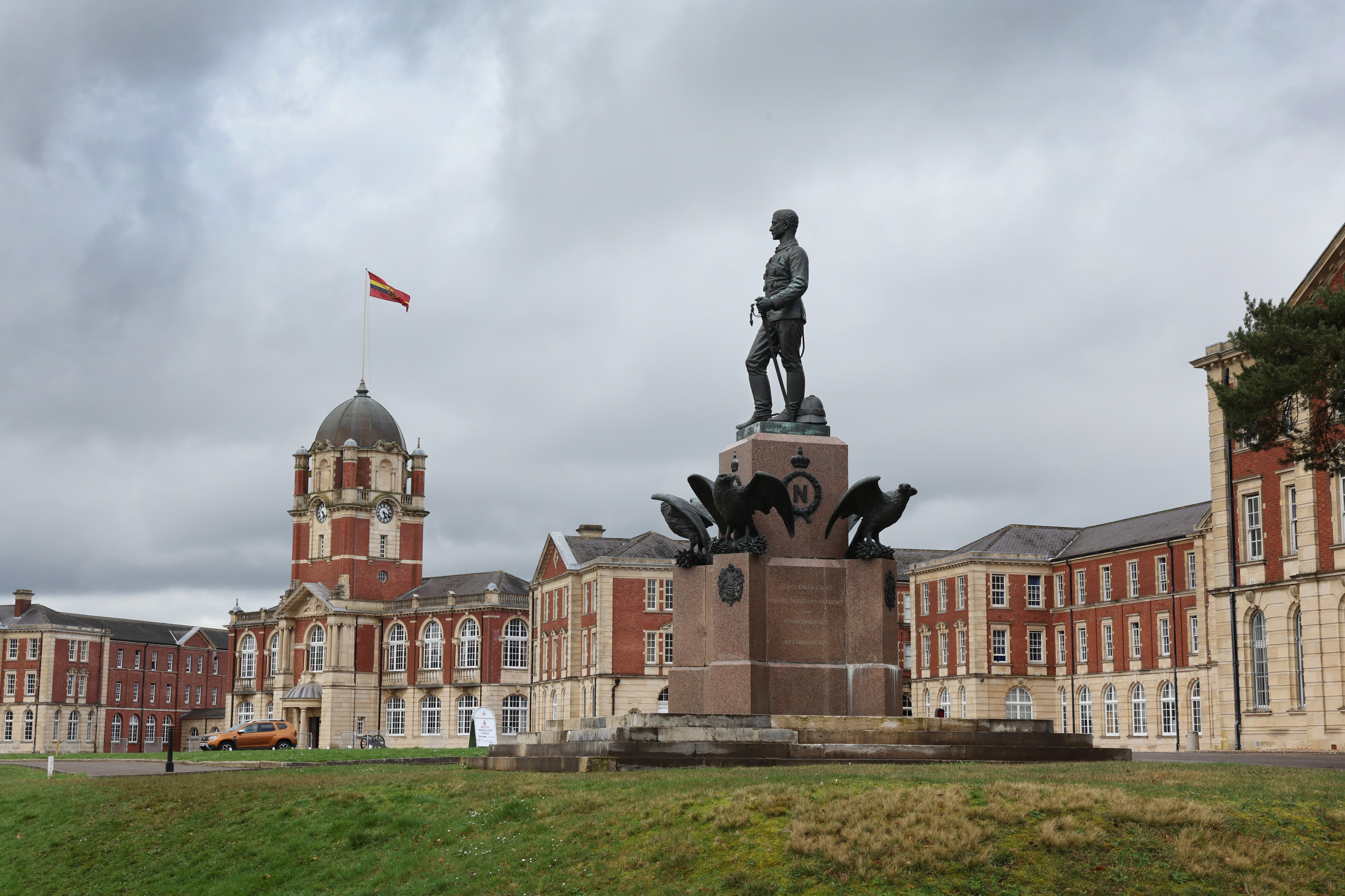A historic building with a grand statue in front of it of a man