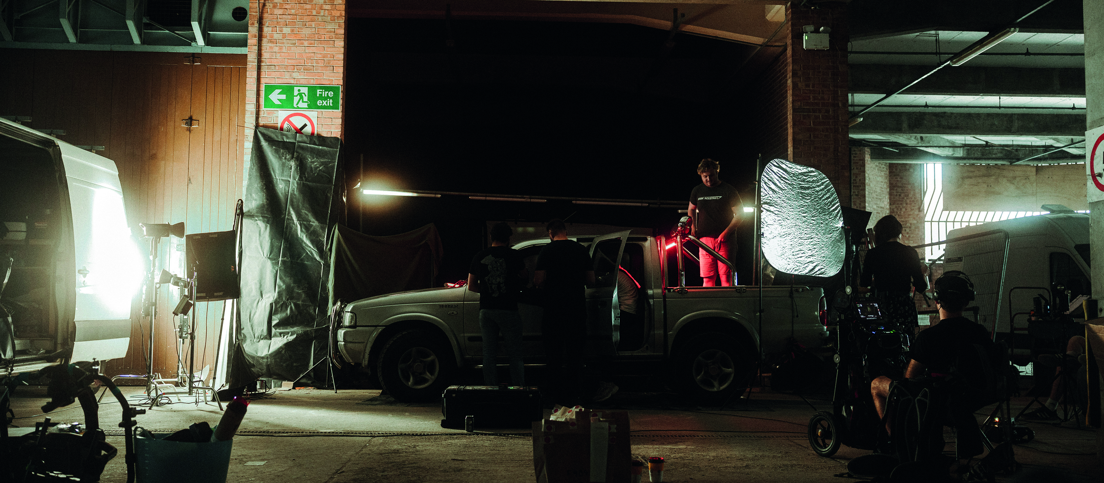 Dark room with cameramen and a van filming 