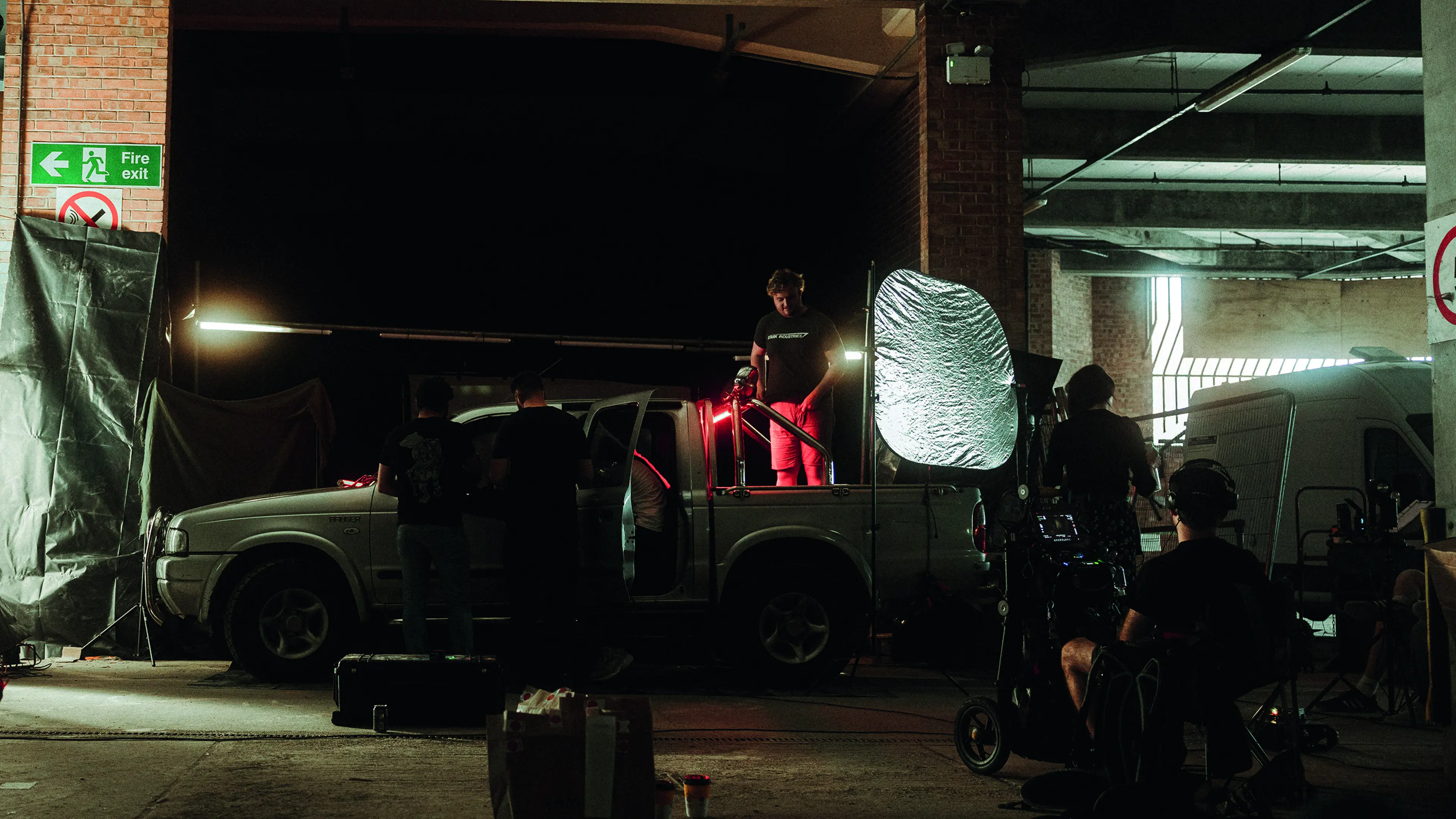 Dark room with cameramen and a van filming