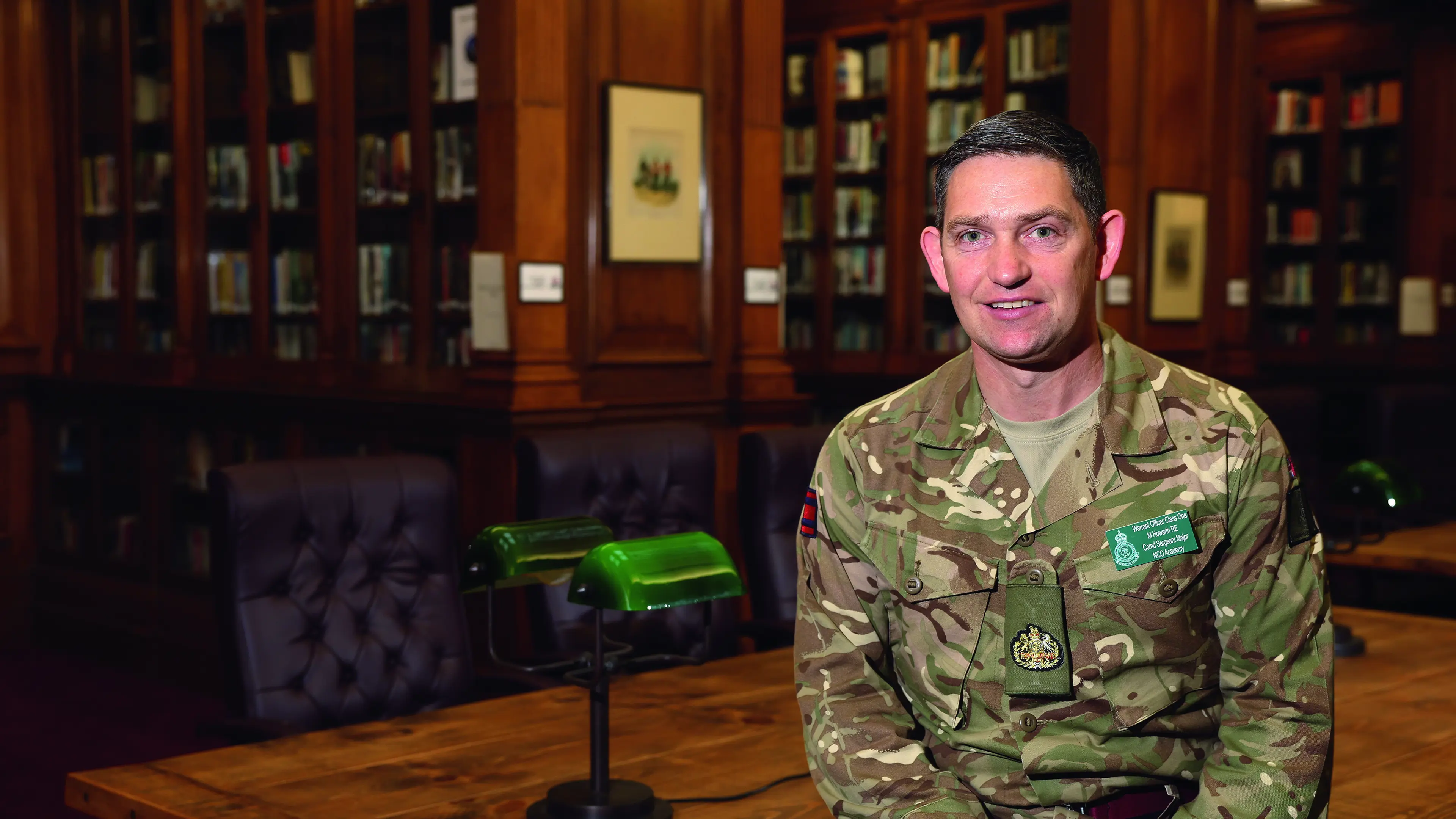 Male soldier, smiling at camera in library