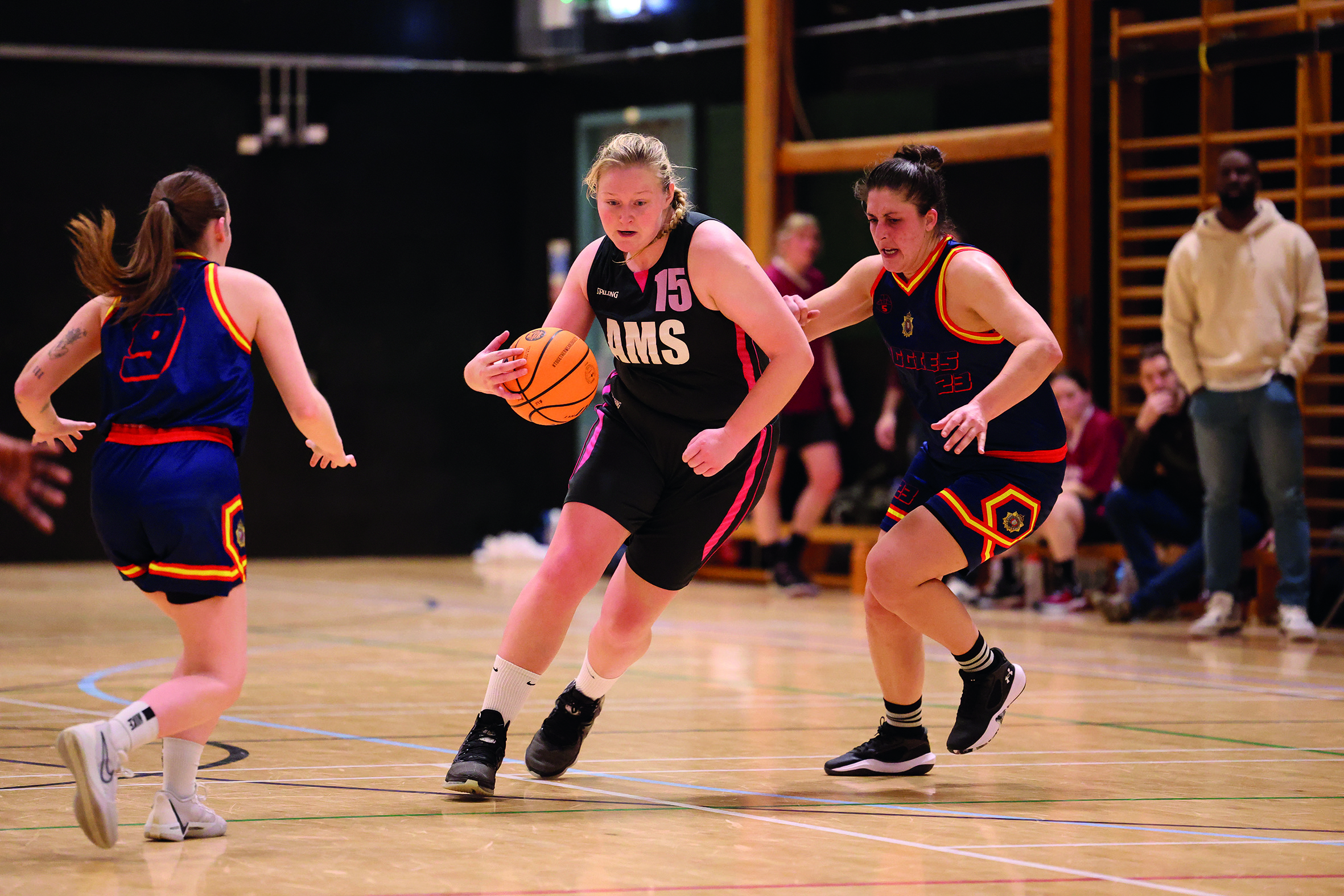 3 women playing a basketball game