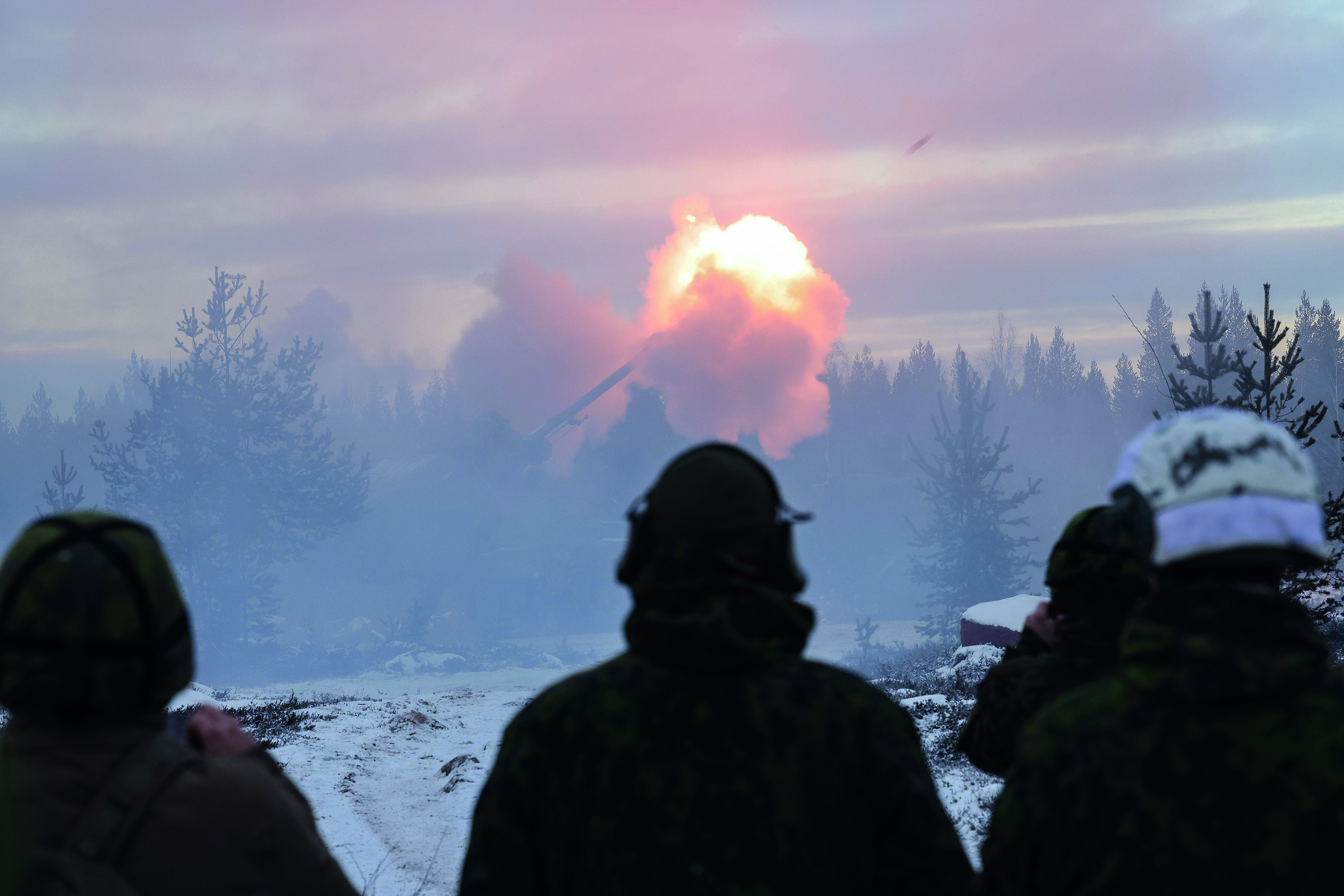 3 soldiers looking out at a tank with a missile that has been set off 