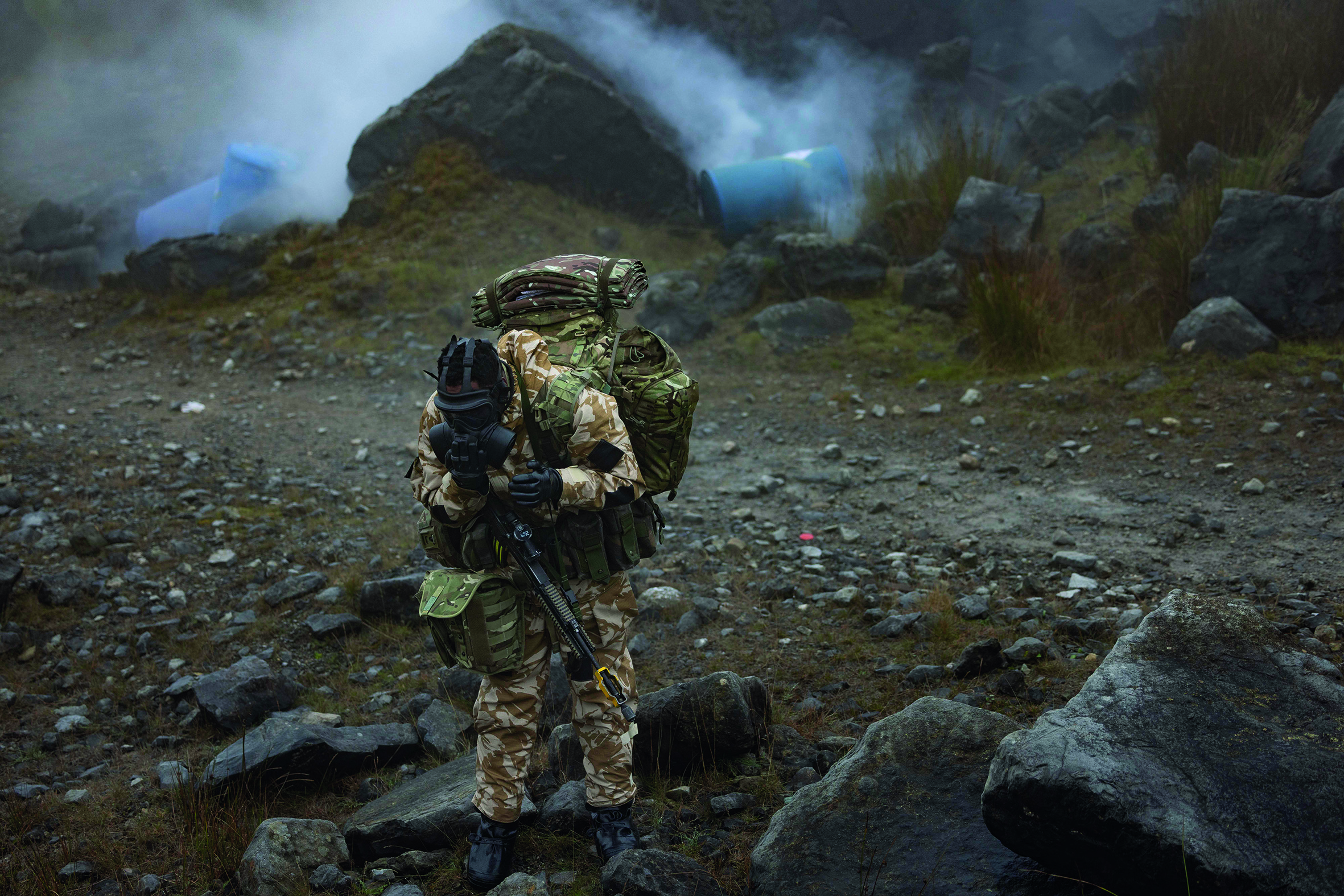 Soldier wearing a gas mask in front of smoke